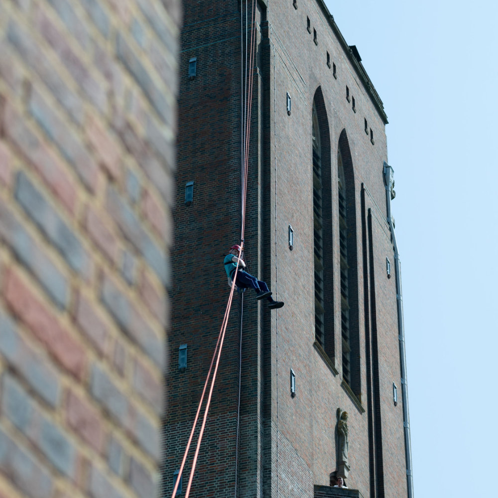 image shows an individual abseiling off the Guildford Cathederal